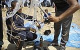 Palestinian protesters prepare an incendiary kite to be flown towards Israel on June 8, 2018 during a demonstration along the Israel-Gaza border fence east of Jabalia in the central Gaza Strip. (AFP/Mohammed Abed)