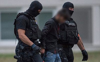 Police officers of a special unit escort Iraqi asylum seeker Ali Bashar, who is suspected of having killed a German teenage girl, from a helicopter to the police headquarters in Wiesbaden, western Germany, after he was flown back from Erbil to Germany on June 9, 2018. His face was blurred under German law( AFP PHOTO / dpa / Boris Roessler)