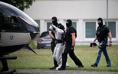 Police officers of a special unit escort Iraqi asylum seeker Ali Bashar, who is suspected of having killed a German teenage girl, to a helicopter in Wiesbaden, western Germany, on June 10, 2018, heading to a prison after Bashar testified. (AFP / dpa / Hasan BRATIC)