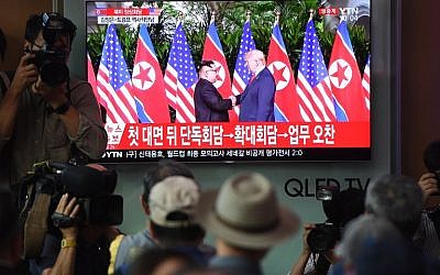 People watch a television screen showing live footage of the summit between US President Donald Trump and North Korean leader Kim Jong Un in Singapore, at a railway station in Seoul on June 12, 2018. ( AFP PHOTO / Jung Yeon-je)