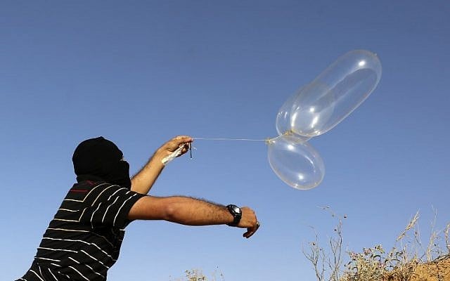 A masked Palestinian man launches a balloon loaded with flammable materials toward Israel, east of Rafah in the southern Gaza Strip on June 17, 2018. (AFP PHOTO / SAID KHATIB) A masked Palestinian man launches a balloon loaded with flammable materials toward Israel, east of Rafah in the southern Gaza Strip on June 17, 2018. (AFP PHOTO / SAID KHATIB)