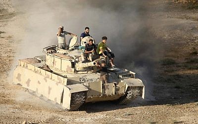 Syrian rebel fighters ride a tank in Daraa, southwestern Syria, on June 23, 2018. (Mohamad ABAZEED/AFP)
