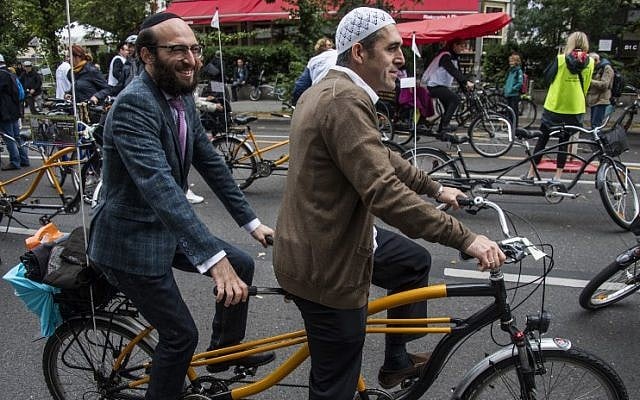 Imam Osman Oers, front, and Rabbi Akiva Weingarten take the start on a tandem of the "meet2respect" bicycle demonstration in Berlin on June 24, 2018. (AFP Photo/John MacDougall) Imam Osman Oers, front, and Rabbi Akiva Weingarten take the start on a tandem of the "meet2respect" bicycle demonstration in Berlin on June 24, 2018. (AFP Photo/John MacDougall)
