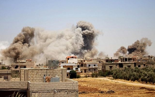 Smoke rises above buildings during an airstrike by Syrian regime forces on the town of Busra al-Harir, east of the southern Syrian province of Daraa on June 24, 2018. (AFP PHOTO / Mohamad ABAZEED) Smoke rises above buildings during an airstrike by Syrian regime forces on the town of Busra al-Harir, east of the southern Syrian province of Daraa on June 24, 2018. (AFP PHOTO / Mohamad ABAZEED)