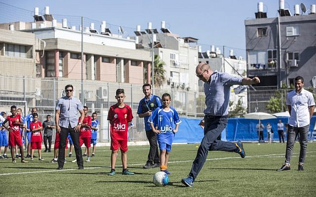 Britain's Prince William, center-right, prepares to kick a ball as he meets with Jewish and Arab children at the Neve Golan Stadium in Jaffa, June 26, 2018. (Heidi Levine/AFP)