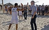 Britain's Prince William (R) high-fives a beach volleyball player during a visit with the mayor of Tel Aviv in the coastal city on June 26, 2018 (AFP PHOTO / POOL / MENAHEM KAHANA)