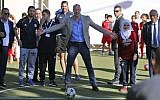 Britain's Prince William (C) prepares to shoot a soccer ball during his meeting with young Palestinian soccer players in the West Bank city of Ramallah on June 27, 2018. (AFP Photo/Abbas Momani)