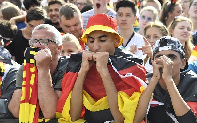 Supporters of the German national football team react as they attend a public viewing event at the Fanmeile in Berlin to watch the Russia 2018 World Cup Group F football match between South Korea and Germany on June 27, 2018. (AFP PHOTO / John MACDOUGALL)