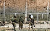 Illustrative: Israeli soldiers carry away an injured Palestinian who the army says tried to breach the border fence east of Jabaliya in the northern Gaza Strip on June 27, 2018. (Said Khatib/AFP)