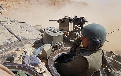 A female soldier operates a tank in the Negev desert, in an undated photograph. (Israel Defense Forces)