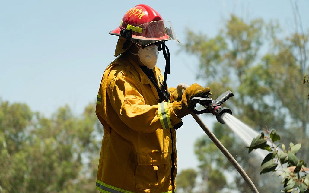 A firefighter puts out a fire in the Beeri forest, June 6, 2018. (Luke Tress/Times of Israel)