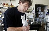 In this March 10, 2014, photo, Masterpiece Cakeshop owner Jack Phillips decorates a cake inside his store in Lakewood, Colorado. (AP Photo/Brennan Linsley)