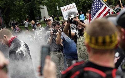 In this June 3, 2018, file photo, photographers capture dueling US demonstrations between antifascists known as antifa and a right wing group called Patriot Prayer in downtown Portland, Oregon. (Mark Graves/The Oregonian via AP, file)