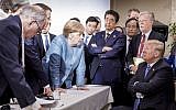 German Chancellor Angela Merkel, center, speaks with US President Donald Trump, seated at right, during the G7 Leaders Summit in La Malbaie, Quebec, Canada, June 9, 2018. (Jesco Denzel/German Federal Government via AP)