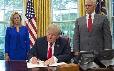 US President Donald Trump signs an executive order to keep families together at the border, but says that the 'zero-tolerance' prosecution policy will continue, during an event in the Oval Office of the White House, on June 20, 2018. (AP Photo/Pablo Martinez Monsivais)