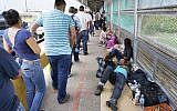 Migrant families rest from their travels to Matamoros, Mexico, along Gateway International Bridge which connects to Brownsville, Texas, as they seek asylum in the United States. (Miguel Roberts/The Brownsville Herald via AP)