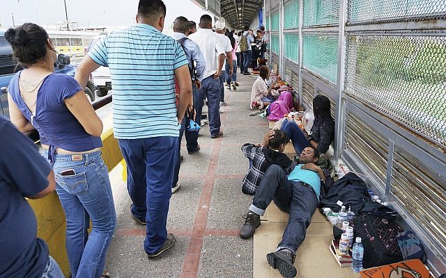 Migrant families rest from their travels to Matamoros, Mexico, along Gateway International Bridge which connects to Brownsville, Texas, as they seek asylum in the United States. (Miguel Roberts/The Brownsville Herald via AP) Migrant families rest from their travels to Matamoros, Mexico, along Gateway International Bridge which connects to Brownsville, Texas, as they seek asylum in the United States. (Miguel Roberts/The Brownsville Herald via AP)