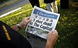 Steve Schuh, county executive of Anne Arundel County, holds a copy of The Capital Gazette near the scene of a shooting at the newspaper's office, Friday, June 29, 2018, in Annapolis, Md. A man armed with smoke grenades and a shotgun attacked journalists in the building Thursday, killing several people before police quickly stormed the building and arrested him, police and witnesses said. (AP Photo/Patrick Semansky)