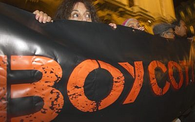 In this Oct. 31, 2012 file photo, French demonstrators and supporters of Palestinians hold a placard with the word 'Boycott' during a demonstration in Paris, France. (AP Photo/Jacques Brinon, File)
