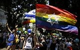 Israelis and tourists wave flags as they participate in the Gay Pride parade in Tel Aviv, June 8, 2018. (AP/Sebastian Scheiner)