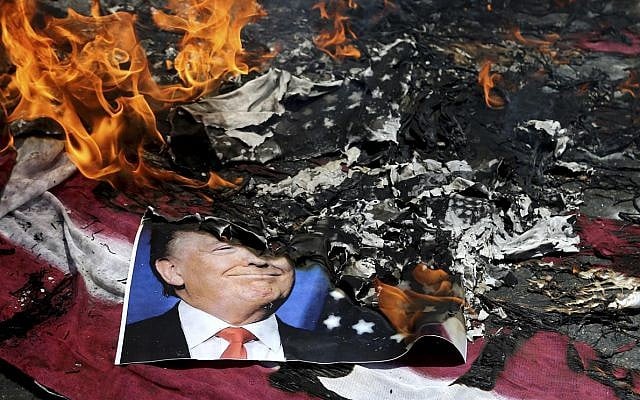 A poster of the US President Donald Trump is set on fire during the annual anti-Israeli Al-Quds, Jerusalem, Day rally in Tehran, Iran, Friday, June 8, 2018 (AP Photo/Ebrahim Noroozi)