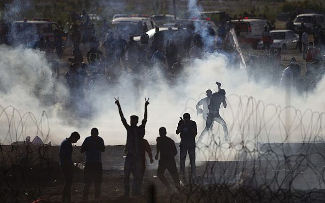Palestinians protesters run from tear gas fired by Israeli troops on the Israel-Gaza border, Friday, June 8, 2018. (AP Photo/Ariel Schalit) Palestinians protesters run from tear gas fired by Israeli troops on the Israel-Gaza border, Friday, June 8, 2018. (AP Photo/Ariel Schalit)
