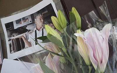 Flowers and a photo of Anthony Bourdain are seen at a make shift memorial outside the building that once housed Le Halles restaurant on Park Avenue, Friday, June 8, 2018, in New York. (AP Photo/Mary Altaffer)