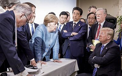German Chancellor Angela Merkel, center, speaks with US President Donald Trump, seated at right, during the G7 Leaders Summit in La Malbaie, Quebec, Canada, on June 9, 2018. (Jesco Denzel/German Federal Government via AP)