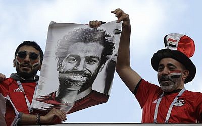 Egyptian supporters lift a photo of national soccer team player Mohamed Salah ahead the group A match between Egypt and Uruguay at the 2018 soccer World Cup in the Yekaterinburg Arena in Yekaterinburg, Russia, Friday, June 15, 2018. (AP Photo/Mark Baker)