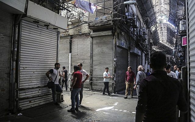 People stand in the old grand bazaar where shops are closed after a protest, in Tehran, Iran, Monday, June 25, 2018.  (Iranian Labor News Agency via AP)