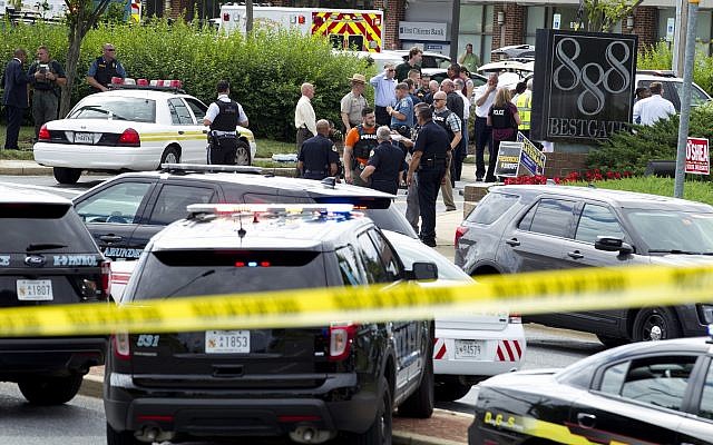 Authorities stage at the office building entrance after multiple people were shot at The Capital Gazette newspaper in Annapolis, Md., June 28, 2018. (AP Photo/Jose Luis Magana) Authorities stage at the office building entrance after multiple people were shot at The Capital Gazette newspaper in Annapolis, Md., June 28, 2018. (AP Photo/Jose Luis Magana)