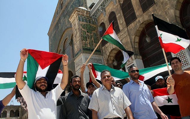 Syrians and Palestinians wave their flags during a festival held inside the Umayyad Mosque in Damascus, Syria on Friday, Aug. 2, 2013 to commemorate Al-Quds (Jerusalem) Day. (AP Photo) Syrians and Palestinians wave their flags during a festival held inside the Umayyad Mosque in Damascus, Syria on Friday, Aug. 2, 2013 to commemorate Al-Quds (Jerusalem) Day. (AP Photo)