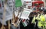 Illustrative: A policeman looks down a line of demonstrators near the Israeli embassy protesting against the action taken against Gaza, in London, Friday, July 11, 2014. (AP/Alastair Grant)