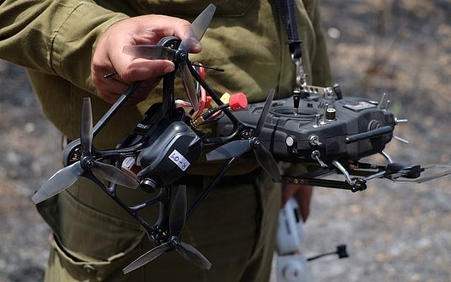 An IDF operator holds up his drone and remote control on June 7, 2018, in a field burned by 'fire kites' from the Gaza Strip. (Judah Ari Gross/Times of Israel) An IDF operator holds up his drone and remote control on June 7, 2018, in a field burned by 'fire kites' from the Gaza Strip. (Judah Ari Gross/Times of Israel)