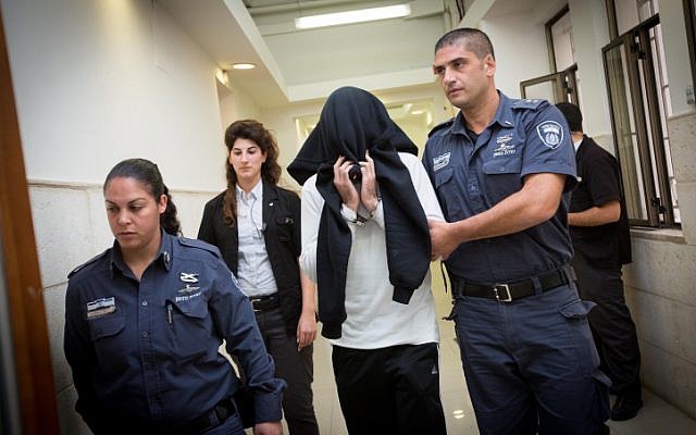 Border Police officer Ben Deri, who was later convicted of killing a 17-year-old Palestinian teenager during riots in the West Bank town of Betunia in 2014, covers his face as he walks into a hearing at the Jerusalem District Court on December 7, 2014. (Miriam Alster/Flash90) Border Police officer Ben Deri, who was later convicted of killing a 17-year-old Palestinian teenager during riots in the West Bank town of Betunia in 2014, covers his face as he walks into a hearing at the Jerusalem District Court on December 7, 2014. (Miriam Alster/Flash90)