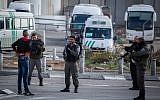 Illustrative: Police officers check a Palestinian man at the entrance to the Shuafat refugee camp in East Jerusalem on December 2, 2015.  (Hadas Parush/Flash90)