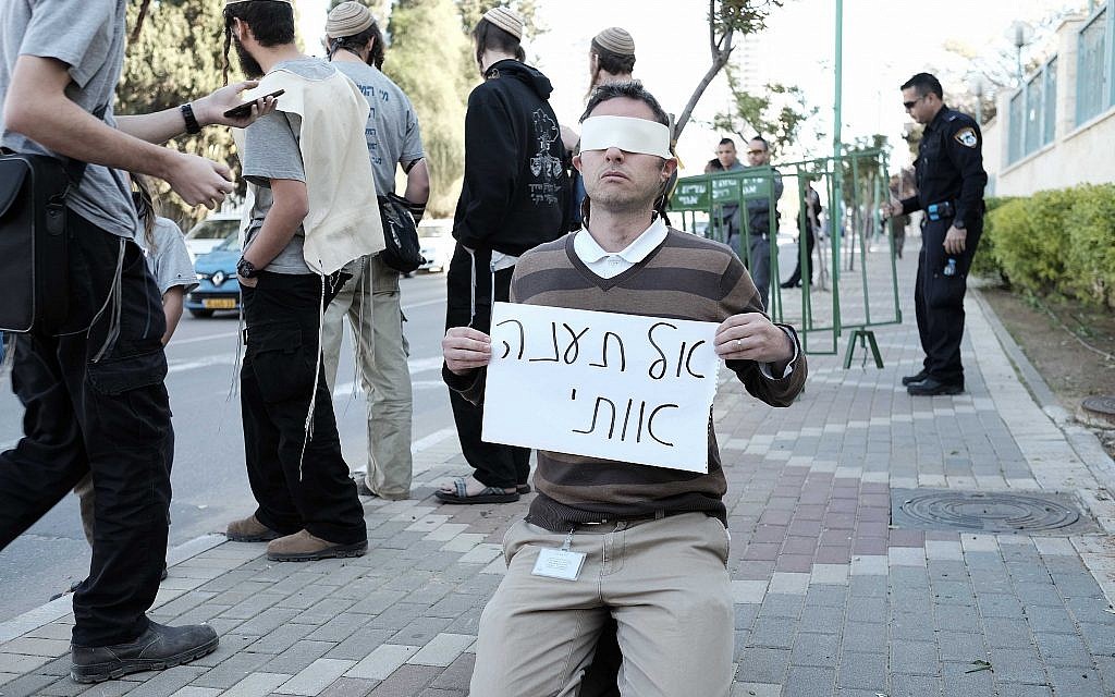 Illustrative: A right-wing Jewish activist holds a sign reading, "Do not torture me" outside the Duma terror attack trial in Petah Tikva on December 28, 2015. (Tomer Neuberg/Flash90) Illustrative: A right-wing Jewish activist holds a sign reading, "Do not torture me" outside the Duma terror attack trial in Petah Tikva on December 28, 2015. (Tomer Neuberg/Flash90)