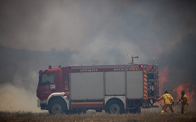 An illustrative photo of Israeli firefighters battling a fire sparked by a flaming object launched from the Gaza Strip, near the border with Palestinian enclave, of June 5, 2018. (Yonatan Sindel/Flash90) An illustrative photo of Israeli firefighters battling a fire sparked by a flaming object launched from the Gaza Strip, near the border with Palestinian enclave, of June 5, 2018. (Yonatan Sindel/Flash90)