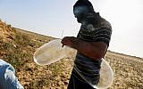 A masked Palestinian prepares a balloon that will be attached to flammable materials to be launched into Israel near the Israeli Gaza border, in Rafah in the southern Gaza Strip on June 17, 2018. (Abed Rahim Khatib/Flash90)
