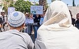 Right wing supporters watch a protest outside a court hearing in Lod on the Duma attack, June 19, 2018. (Roy Alima/Flash90)