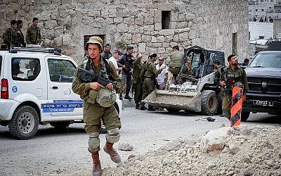 Israeli soldiers at the scene of an attempted ramming attack in the West Bank city of Hebron on June 2, 2018. (Wisam Hashlamoun/Flash90)