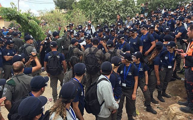 Police and Border Police officers at the Netiv Ha'avot outpost in the Gush Etzion area of the West Bank during the demolition of 15 illegally-built homes, on June 12, 2018. (Luke Tress/Times of Israel)