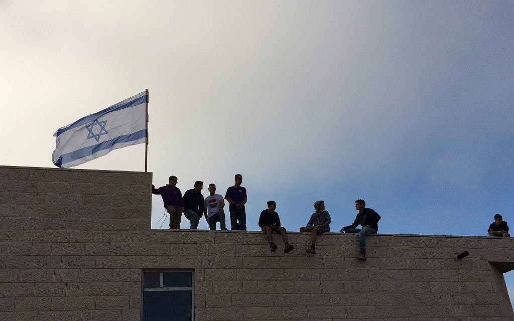 Protesters at the Netiv Ha'avot illegal settlement outpost in the Gush Etzion area of the West Bank shortly before the expected demolition of 15 homes built illegally on private Palestinian land, June 12, 2018. (Luke Tress/Times of Israel)