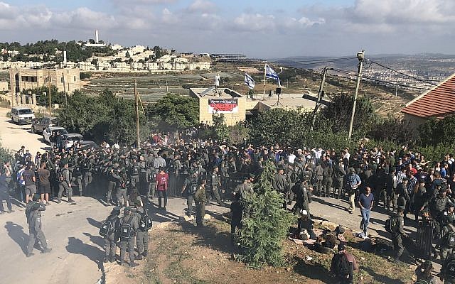 Border Police and protesters at the Netiv Ha'avot outpost in the Gush Etzion area of the West Bank shortly before the expected demolition of 15 homes built illegally on private Palestinian land, on June 12, 2018. (Jacob Magid/Times of Israel)