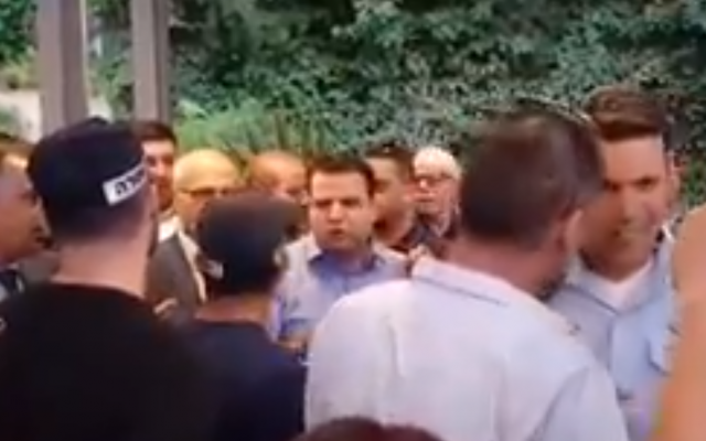 Joint (Arab) List MK Ayman Odeh (C) argues with police during an event in East Jerusalem hosted by the Popular Front for the Liberation of Palestine and Democratic Front for the Liberation of Palestine terror groups on June 18, 2018. (Screen capture: Twitter) Joint (Arab) List MK Ayman Odeh (C) argues with police during an event in East Jerusalem hosted by the Popular Front for the Liberation of Palestine and Democratic Front for the Liberation of Palestine terror groups on June 18, 2018. (Screen capture: Twitter)