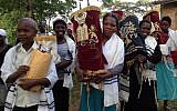 Jewish Ugandan women carry Torah scrolls in Nabagoye, Uganda (Courtesy of Be’chol Lashon)