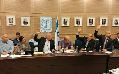 Members of the Knesset Defense and Foreign Affairs Committee vote in favor of a bill to slash funds to the Palestinian Authority by the amount Ramallah pays out to convicted terrorists, June 11, 2018. (Courtesy)
