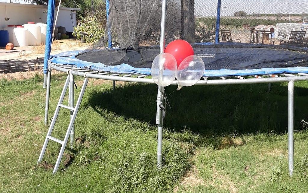 A cluster of balloons with a small explosive device attached to them, which landed and got stuck on a trampoline in a backyard in the Eshkol region of southern Israel on June 20, 2018. (Eshkol Security) A cluster of balloons with a small explosive device attached to them, which landed and got stuck on a trampoline in a backyard in the Eshkol region of southern Israel on June 20, 2018. (Eshkol Security)