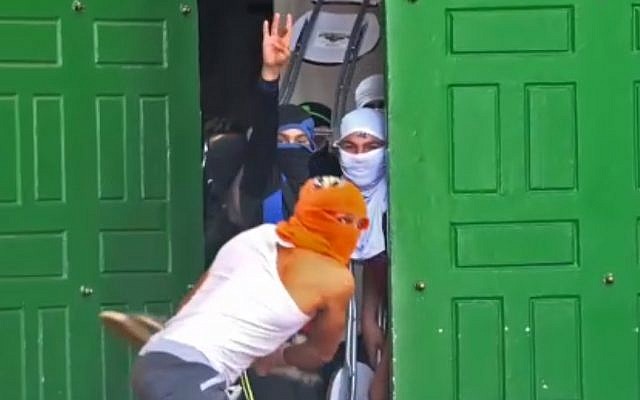 Palestinians throw chairs and other objects from inside the Al-Aqsa Mosque on Jerusalem's Temple Mount, June 7, 2018. (Screenshot from police footage) Palestinians throw chairs and other objects from inside the Al-Aqsa Mosque on Jerusalem's Temple Mount, June 7, 2018. (Screenshot from police footage)