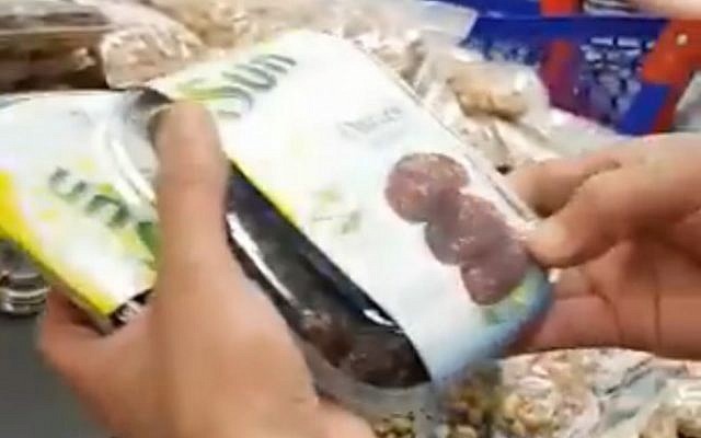 A French shop manager removes Israeli dates from a Ramadan products stall following complaints by a Muslim customer (Video screenshot)